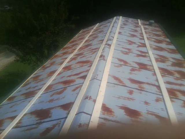 Rusted metal roof panels with new wood purlins before replacement — Storm Damage Roof Repair in Quogue by Roofing Brothers