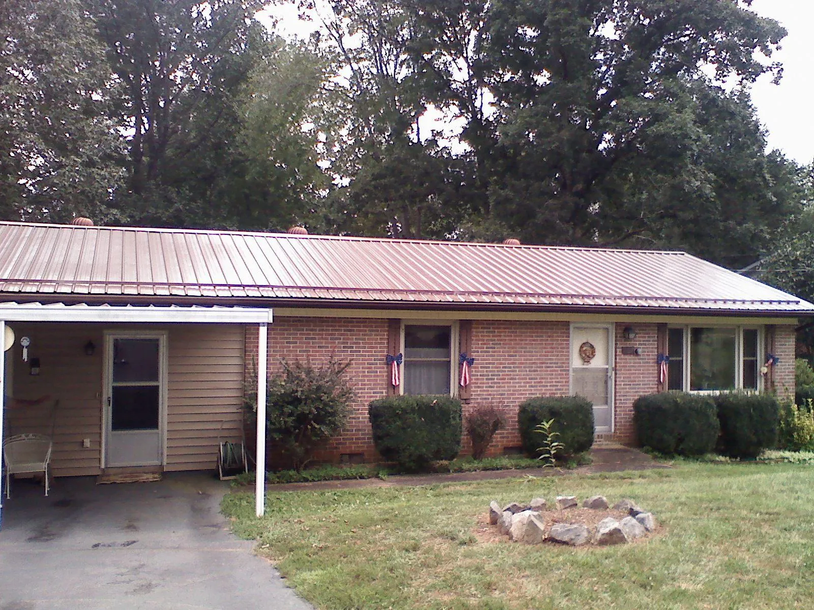 Bronze metal roof and carport on a brick ranch home — Roof Repair work by our crew in Quogue